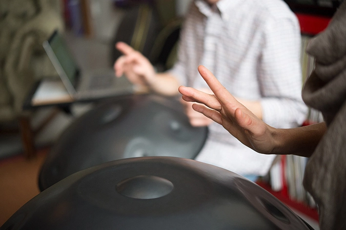 نمایی نزدیک از دستان دو نفر در حال زدن هنگ‌درام
