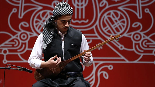 شخصی در حال نواختن تنبور در یک جشنواره موسیقی